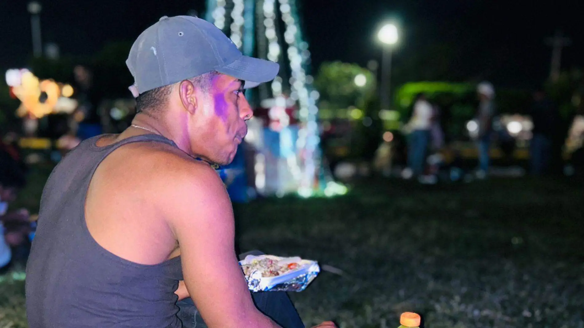 hombre migrante comiendo en el parque